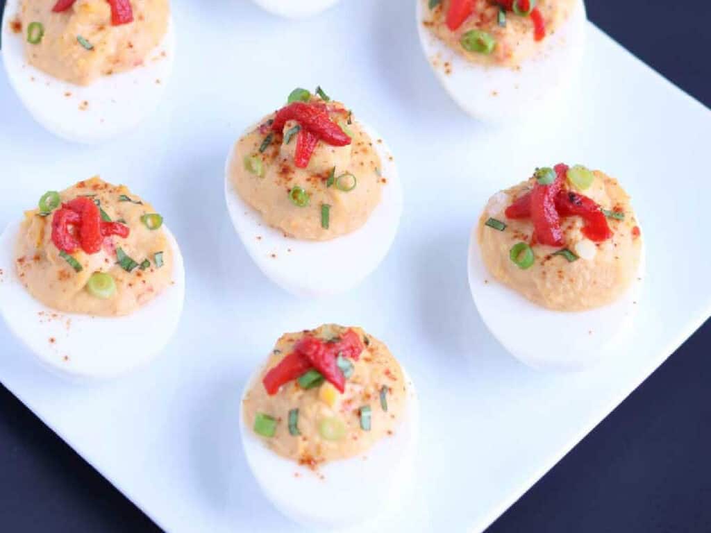 mediterranean deviled eggs topped with roasted red peppers